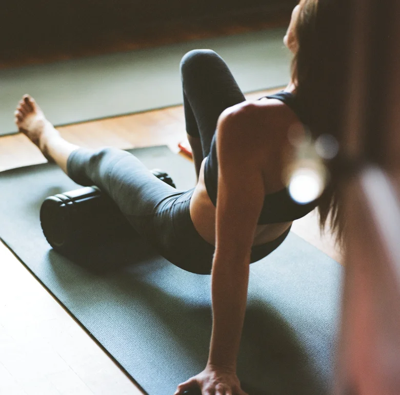 Student stretching over a foam roller