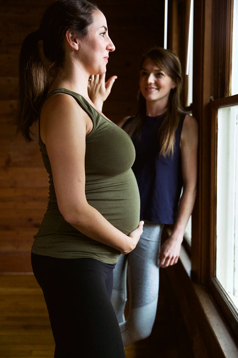 Pregnant student talking with her teacher by the studio window
