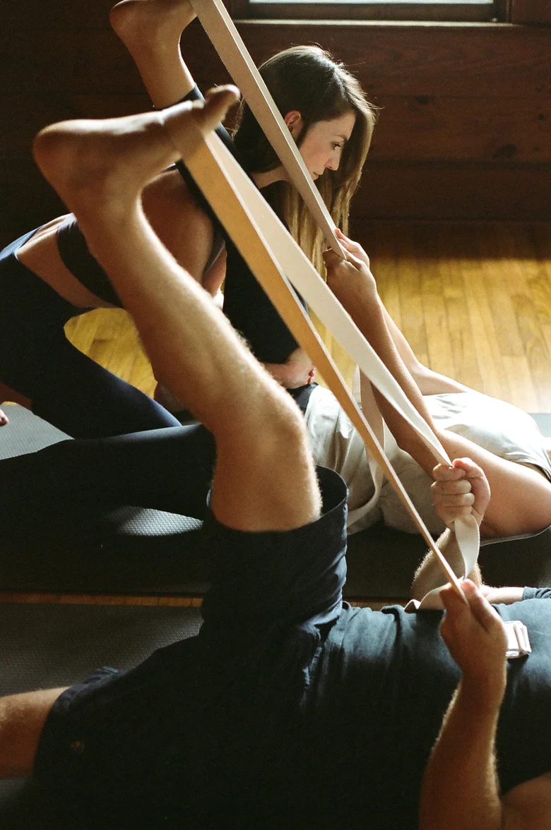 Student using a strap for a reclined hamstring stretch